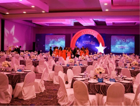 Cena de gala de Avon con escenario y pantallas